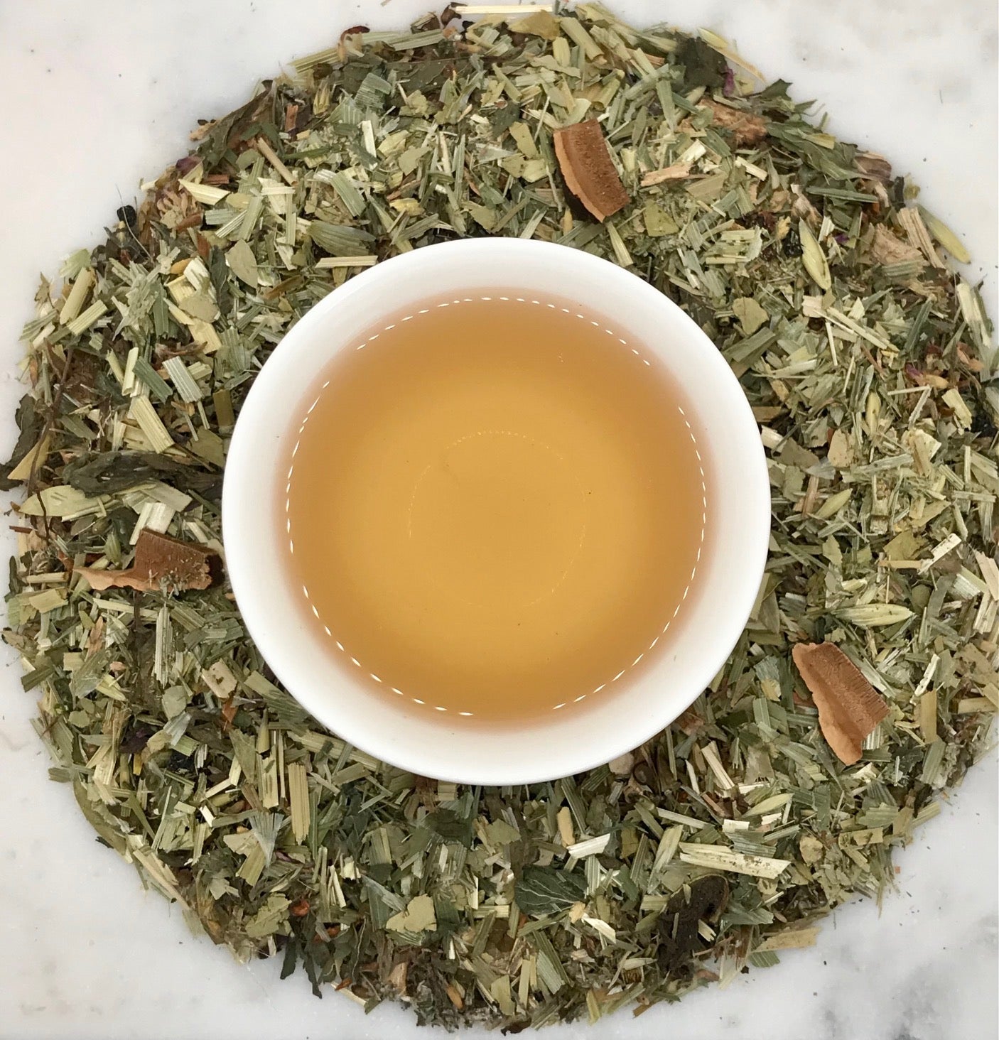 Cup of herbal tea surrounded by dried herbs and botanicals, Herbal Tea for Gut Health support