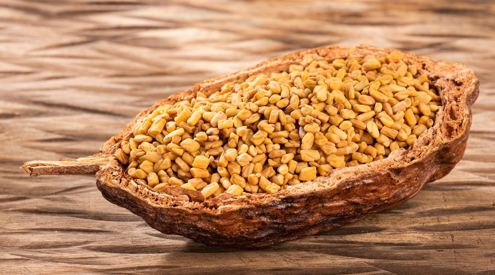 Showing fenugreek seeds (Trigonella foenum-graecum) in a rustic bowl, highlighting their small, angular shape and golden-yellow colour.