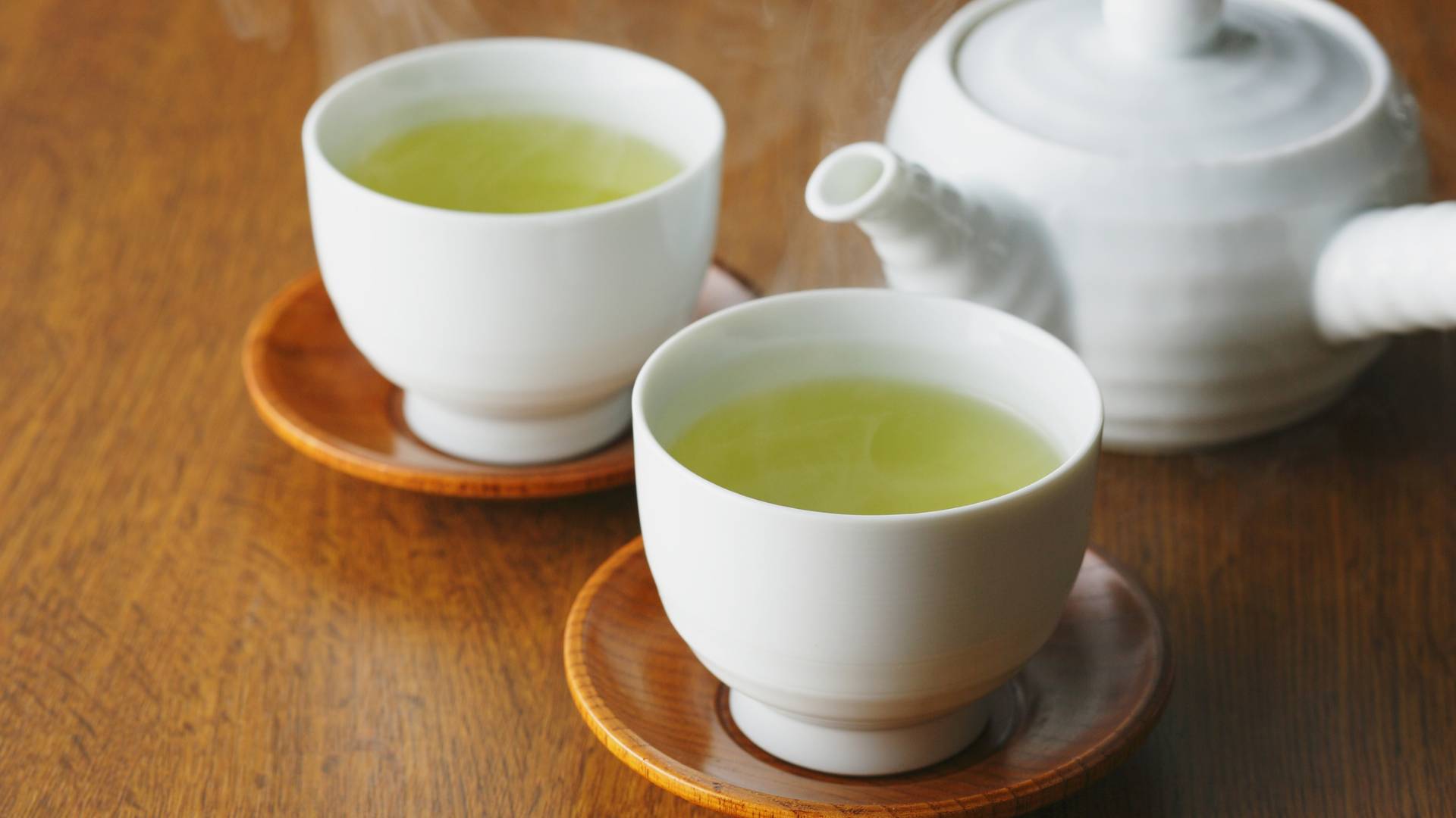 Two cups of herbal tea with teapot on wooden table, soothing herbal tea for mood balance support