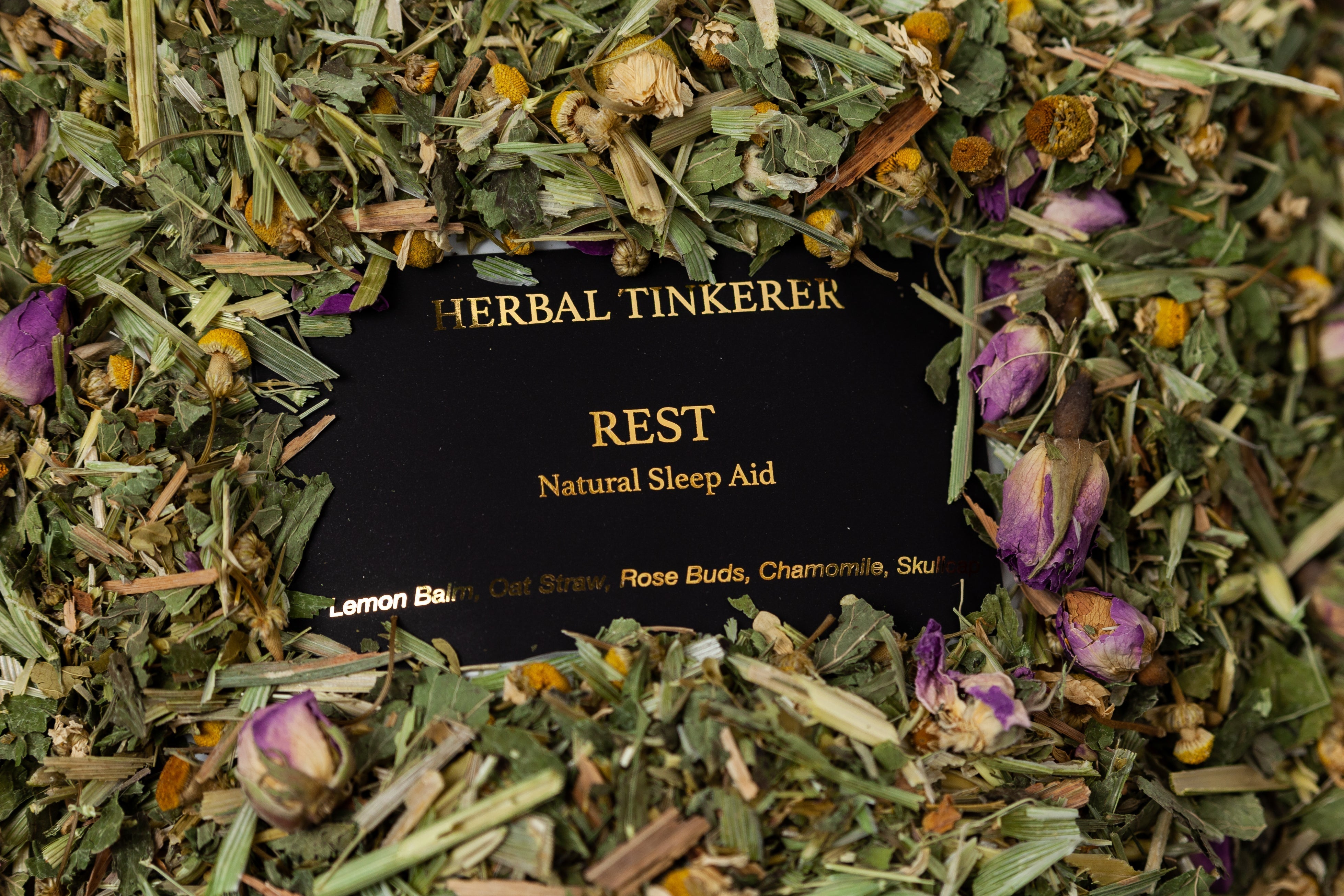 Rest blend surrounded by dried herbs and flowers, natural herbal tea for sleep support
