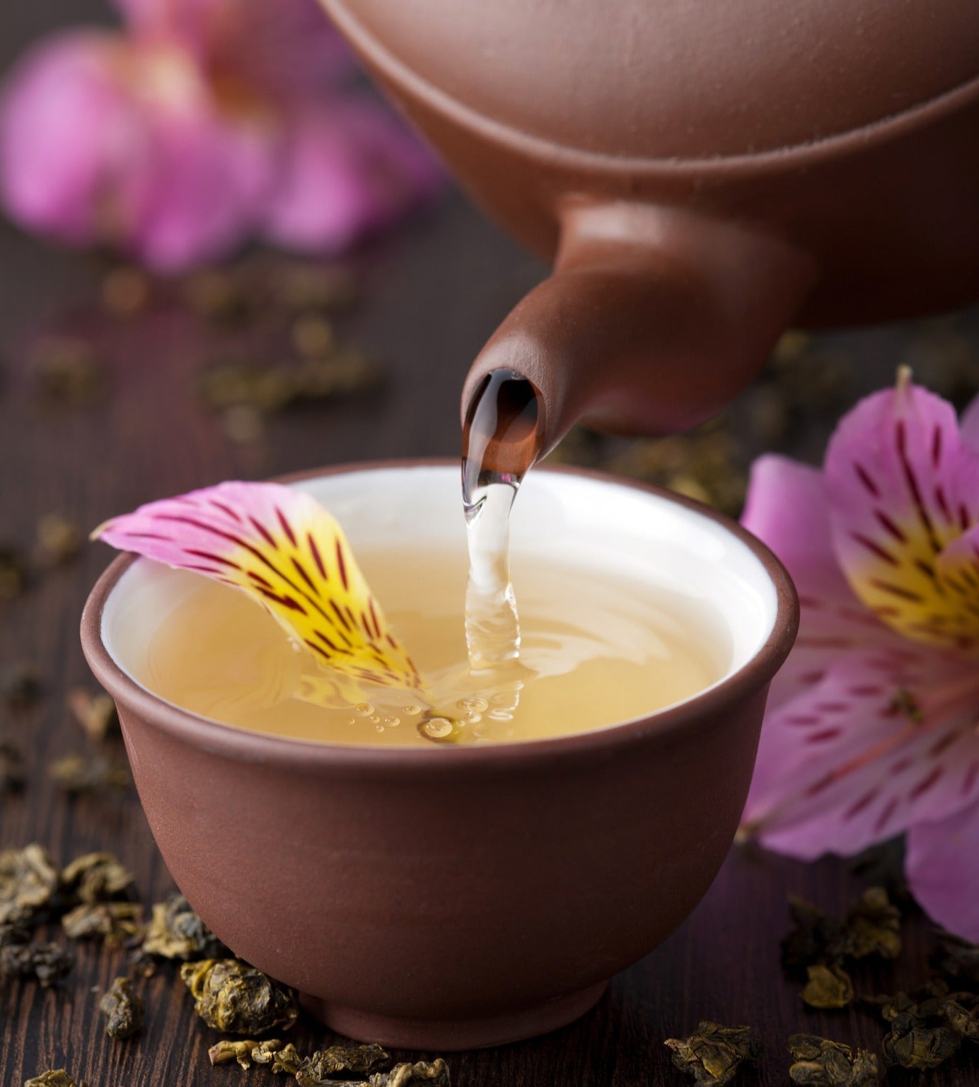 Pouring herbal tea for a herbal parasite cleanse guide.