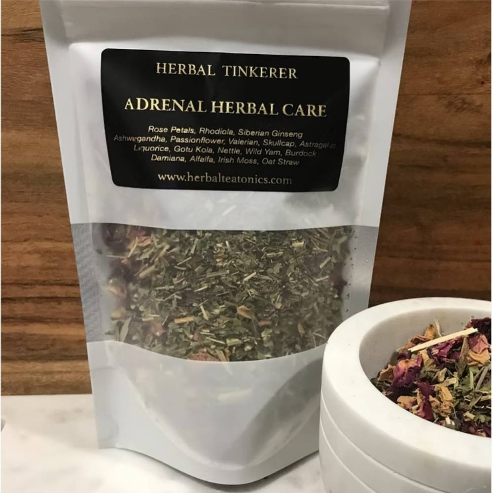 Herbal tea packaging labeled 'Adrenal Herbal Care' from 'Herbal Tinkerer' on a wooden surface.