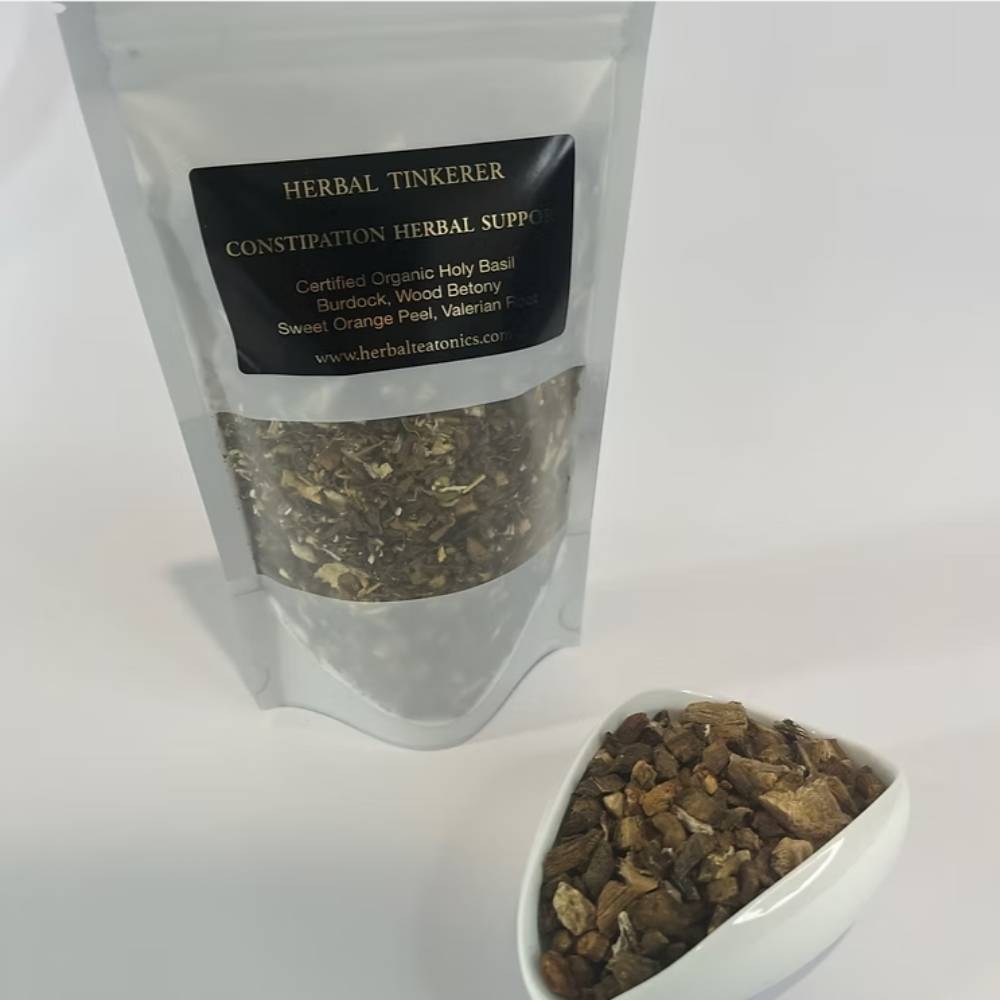 Herbal tinkerer constipation herbal supplement packaging with a white container of dried herbs on a light background.