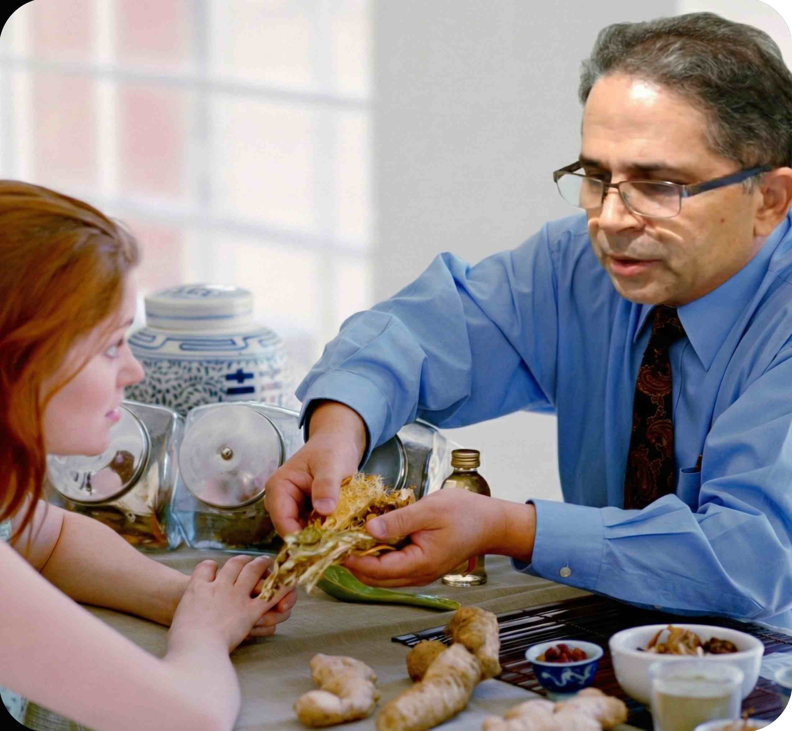 Man and child at a table with food, possibly sharing a sandwich.